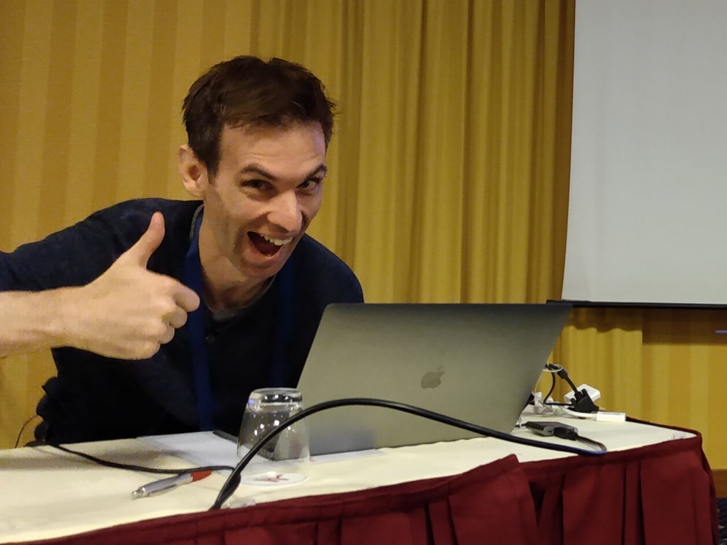 Julien, au début d'une conférence, qui réalise que son Mac n'est pas compatible avec un vidéo projecteur standard.